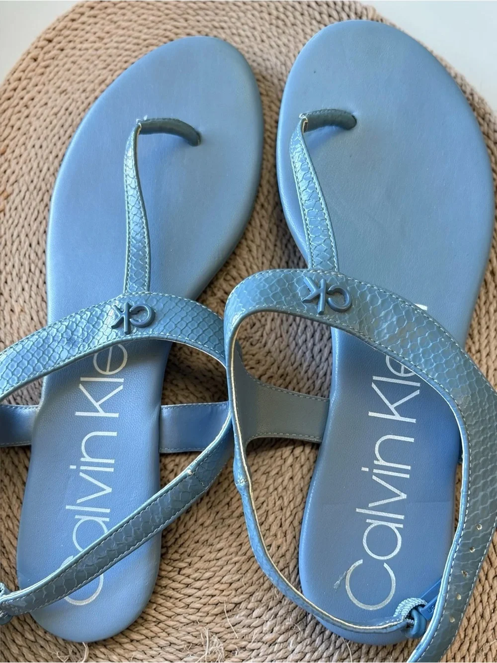 Calvin Klein Shellie blue snake print flat thong sandals feature an ankle strap